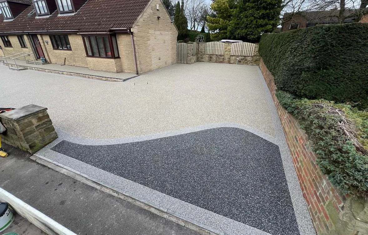 Two-tone resin driveway with a sweeping curved join